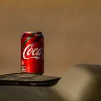 Coca-cola can on the dashboard of a car in the desert