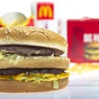 A Big Mac fries and a coke sitting on a reflective surface