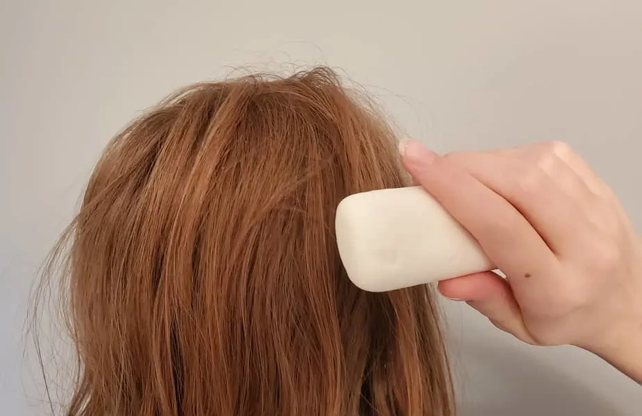 Holding a Bar of Soap Against a Head of Hair