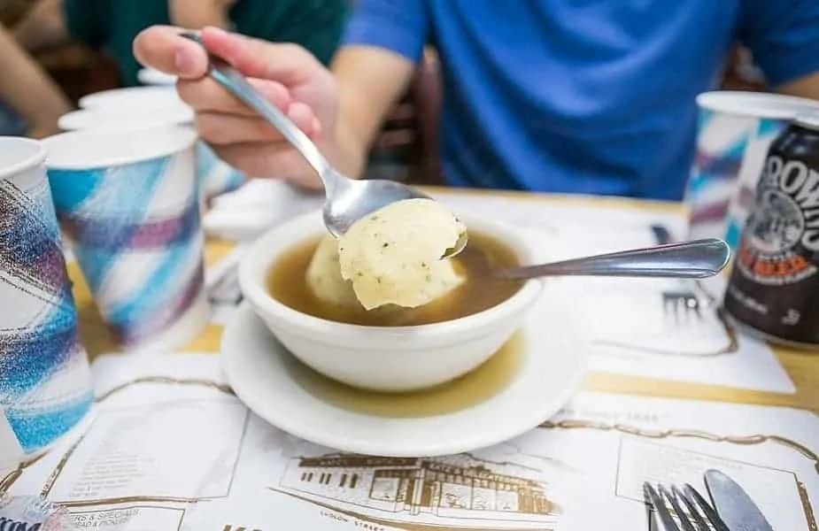 Matzo Ball on a Spoon Over a Bowl of Soup