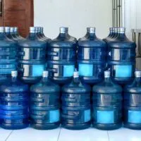 Row of large bottles of drinking water in a garage