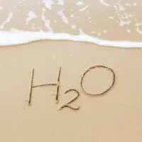 H2O written in sand near ocean