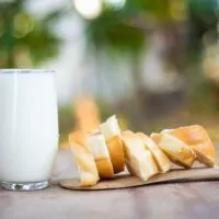 A Glass of Milk Next to Sliced Bread