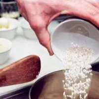 Hand Adding Rice to a Pot