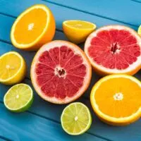 Oranges grapefruits limes and lemons lying on a blue wooden table