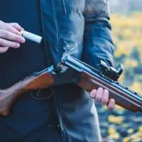 Hunter reloading a shotgun in a field