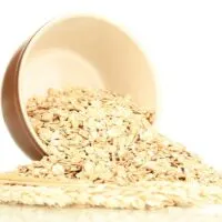 Oats spilling out of a brown bowl