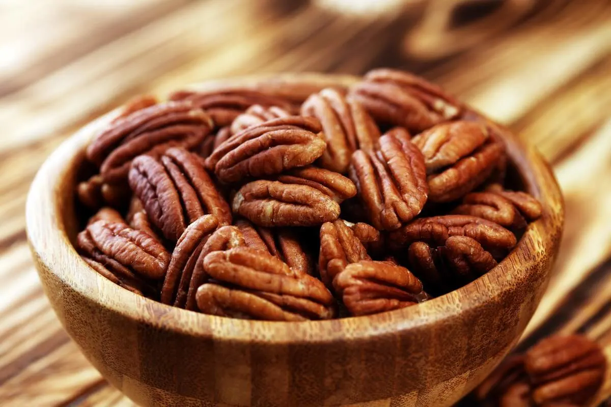 Close-up of a bowl of shelled pecans on a table