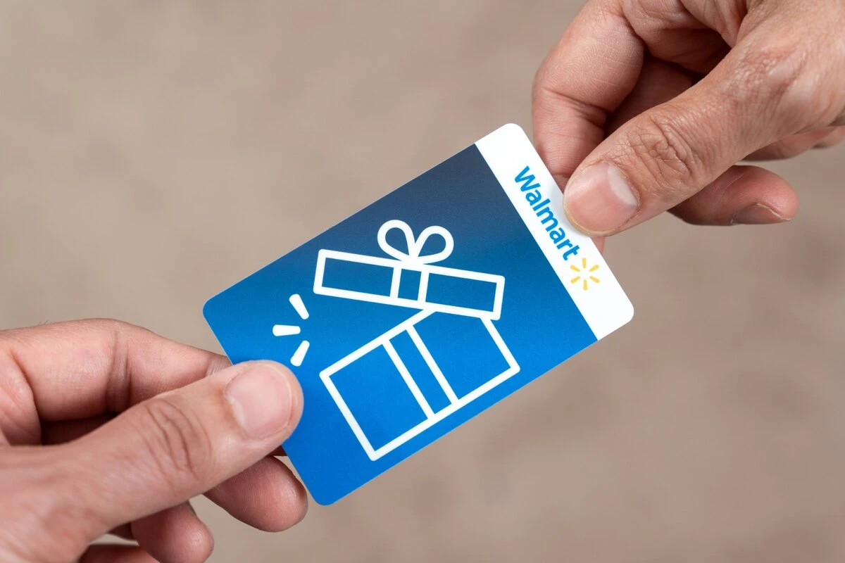Hand giving out a Walmart color gift card to another person